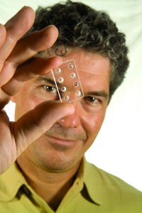 Michael Ramsey holds the lab-on-a-chip. (photo by Steve Exum)