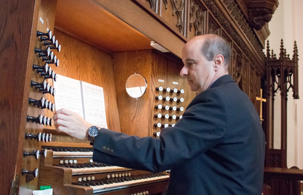 Andy Lang plays the organ in Chapel of the Cross on Franklin Street. He says music brings balance to his technology-intensive life. (photo by Kristen Chavez)