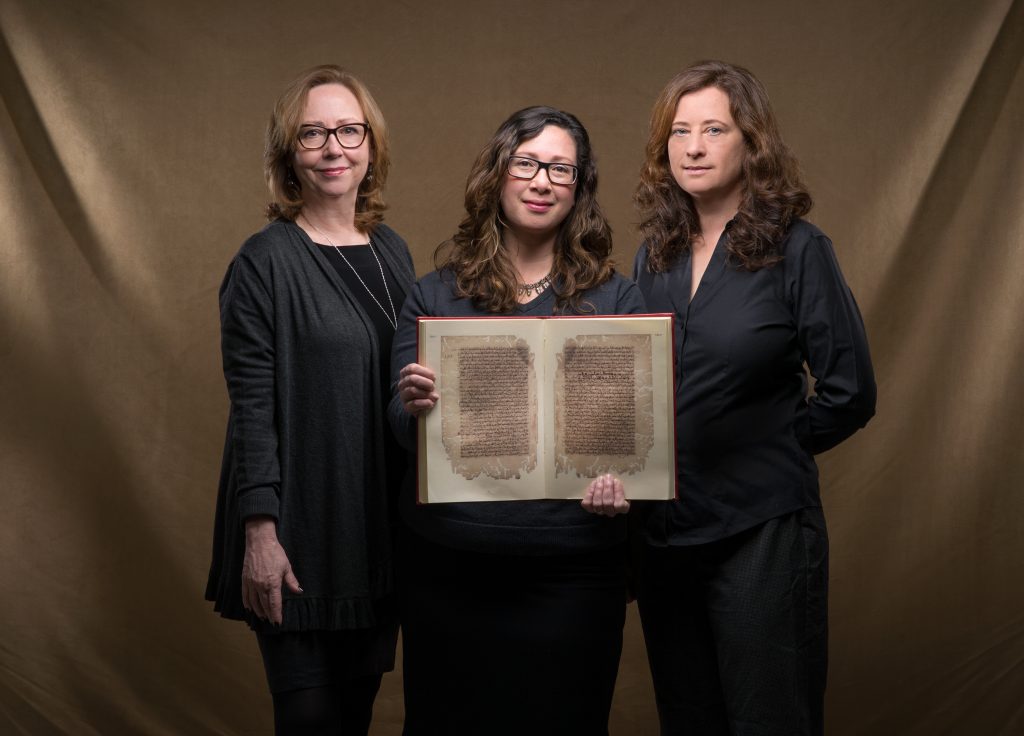 Jan Chambers, Glaire Anderson and Laura Miller hold a facsimile of an 11th-century Arabic manuscript describing the flight of inventor Abbas ibn Firnas. “The manuscript has yet to be incorporated into scholarship on aviation history,” said Anderson. (photo by Steve Exum)  