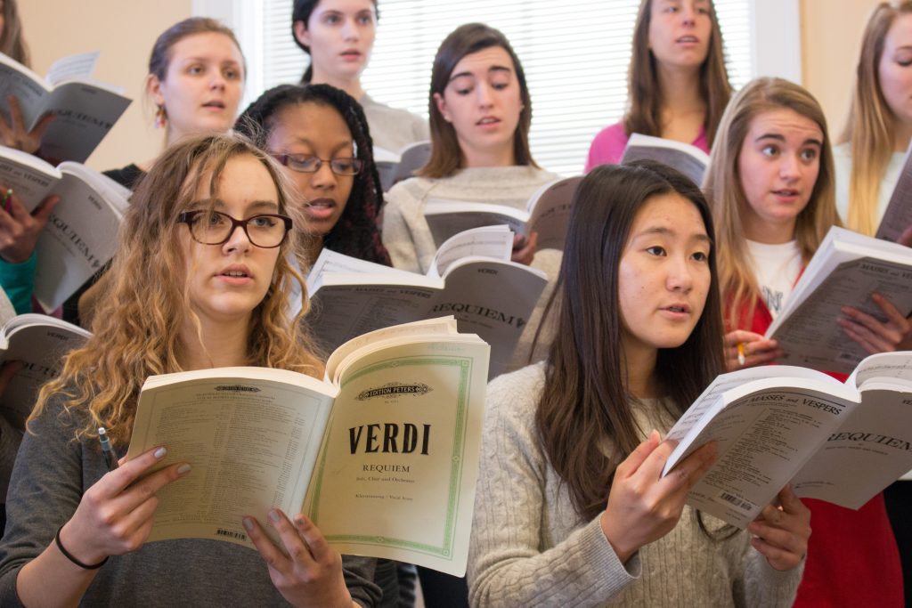 Members of the Carolina Choir, one of four choral groups performing the Defiant Requiem, practice at a rehearsal led by Susan Klebanow. (photo by Kristen Chavez)