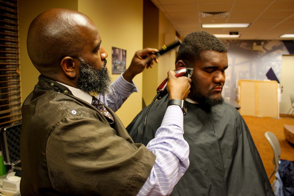 Langden Ramseur enjoys a moment in the chair of local barber Brian Toulan. (photo by Tyris Gillis)