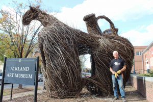 Patrick Dougherty poses in front of one of the stickwork sculptures outside of Ackland Art Museum.